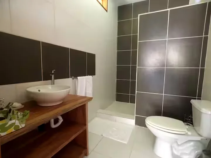 Modern bathroom with wooden vanity and tiled shower
