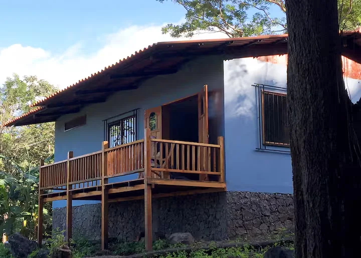 The wooden veranda of Casa Mono Congo among mature trees