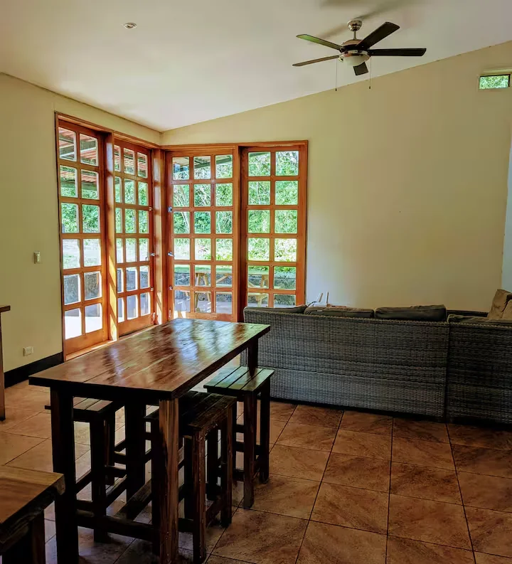 Open-plan dining and lounge area with wooden windows